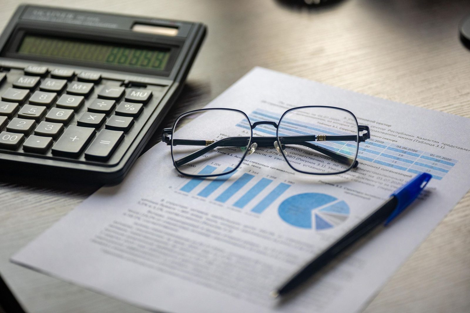 Document avec une calculatrice, un stylo et des lunettes